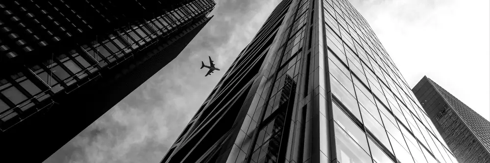 Airplane flying between city skyscrapers